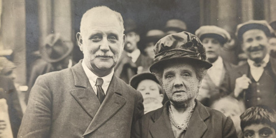 A sepia toned photo picture of a crowd of people in 1930s clothing